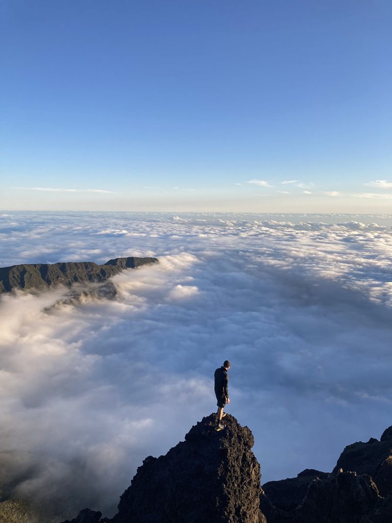 Wanderer auf einem Felsen vor einem Wolkenmeer