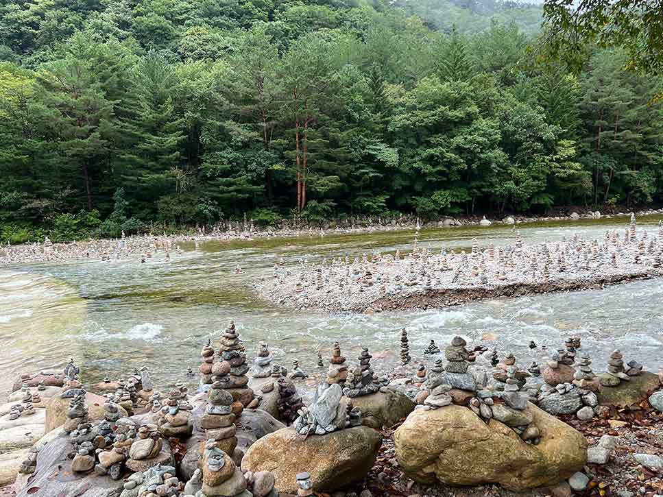 Unzählige Steinmänchen auf und neben dem Fluss