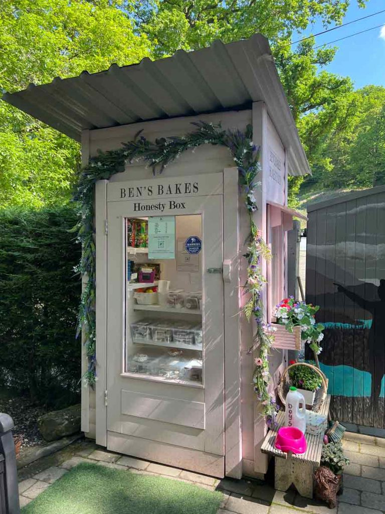Eine rosane honesty box, mit allerlei Waren